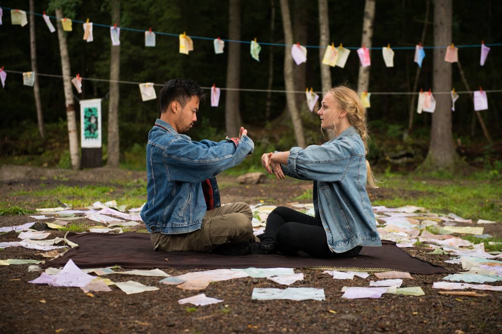 Tony Tran and Hedda Rivrud perform How to Love You outdoors among handwritten notes.
