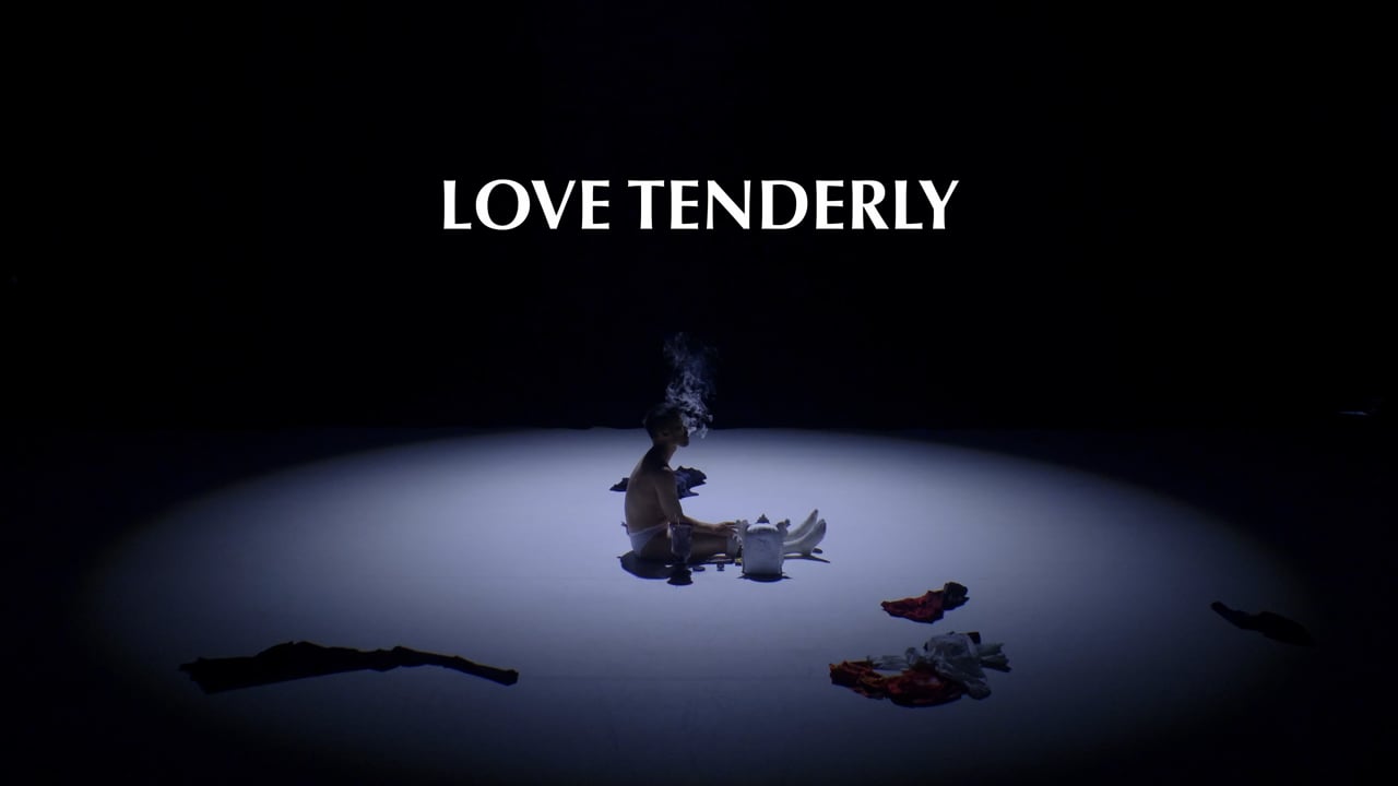 Tony Tran seated alone in a pool of stage light beneath the Love Tenderly title.