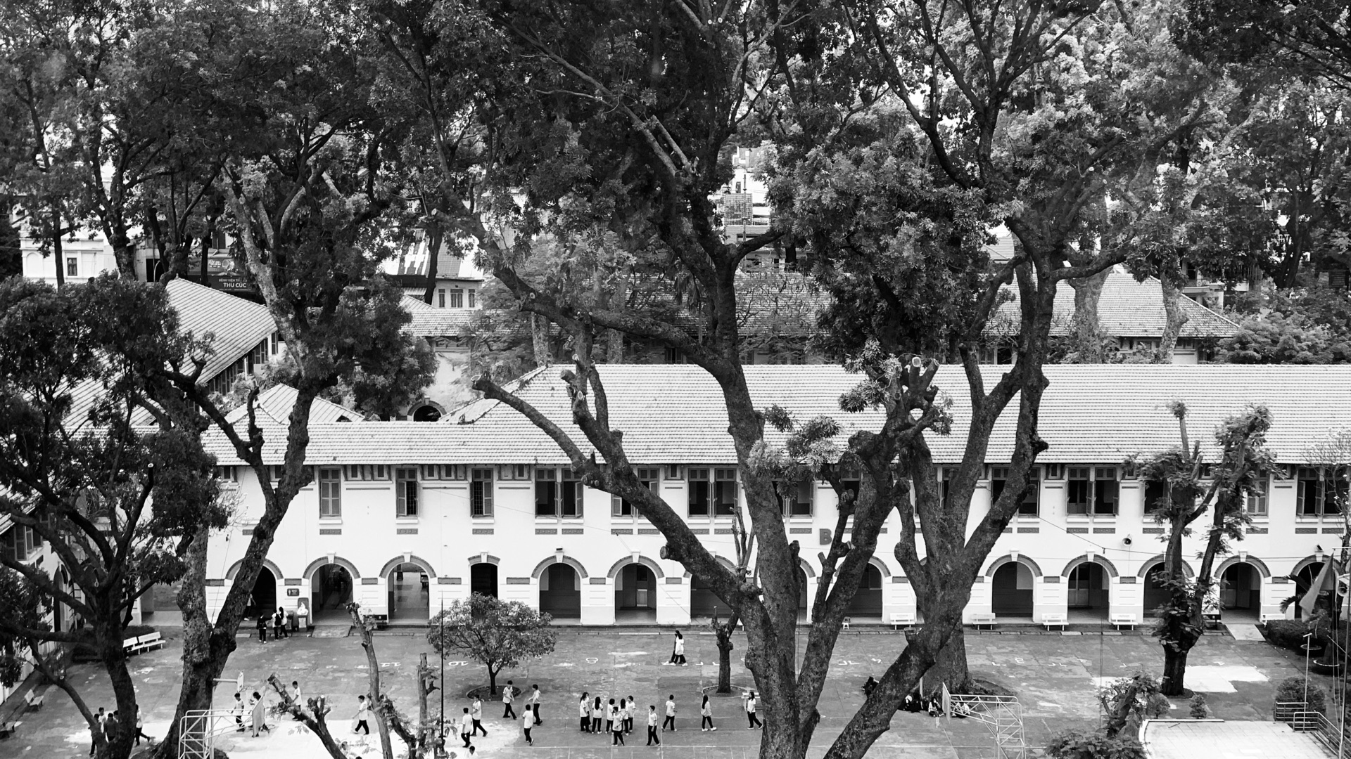 A quiet courtyard in Saigon framed by trees and residential buildings.